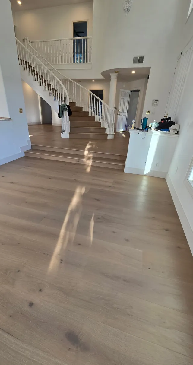 Engineered hardwood floor in a Pacific Palisades entry leading to a curved staircase with matching treads