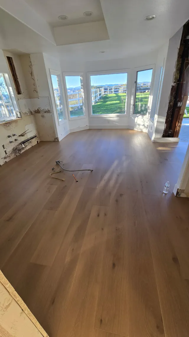 Wide-plank engineered hardwood in a Pacific Palisades bay-window room