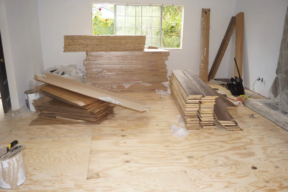 Hardwood flooring planks and cartons staged inside a Pasadena residence before installation