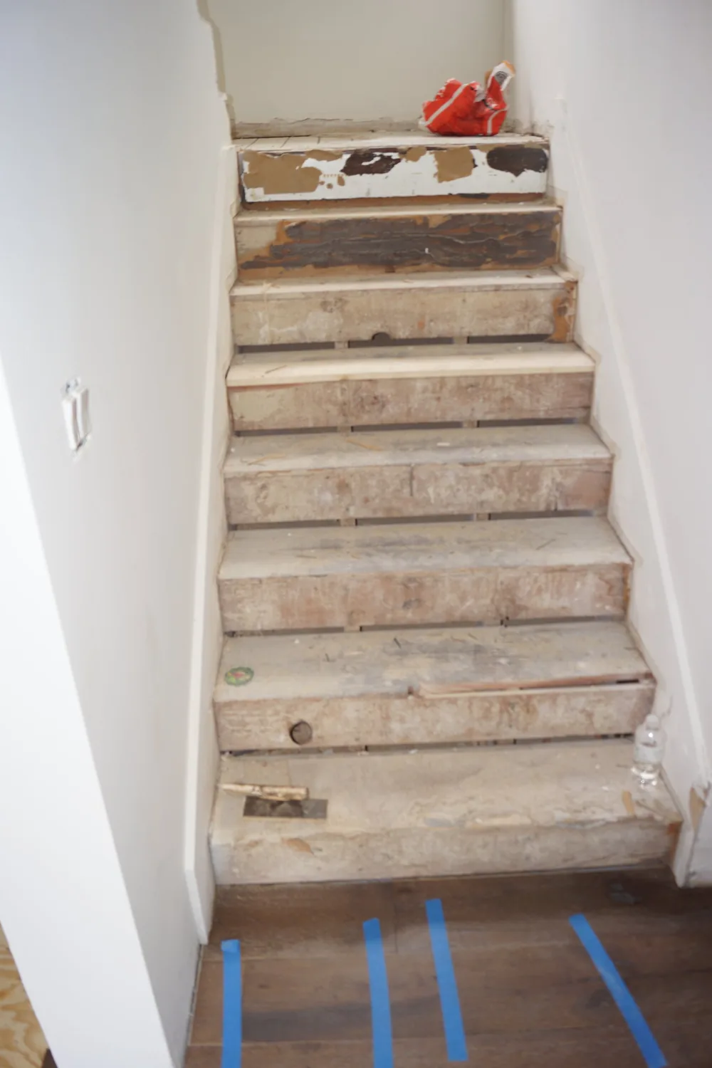 Existing residential staircase with old treads exposed during preparation for a Pasadena flooring renovation