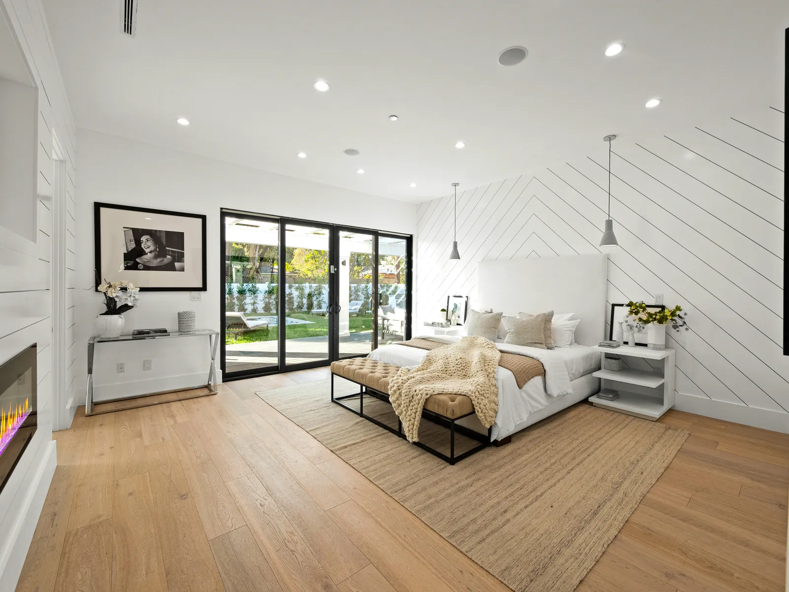 Primary bedroom with sliding doors to the yard and wire-brushed European white oak floors