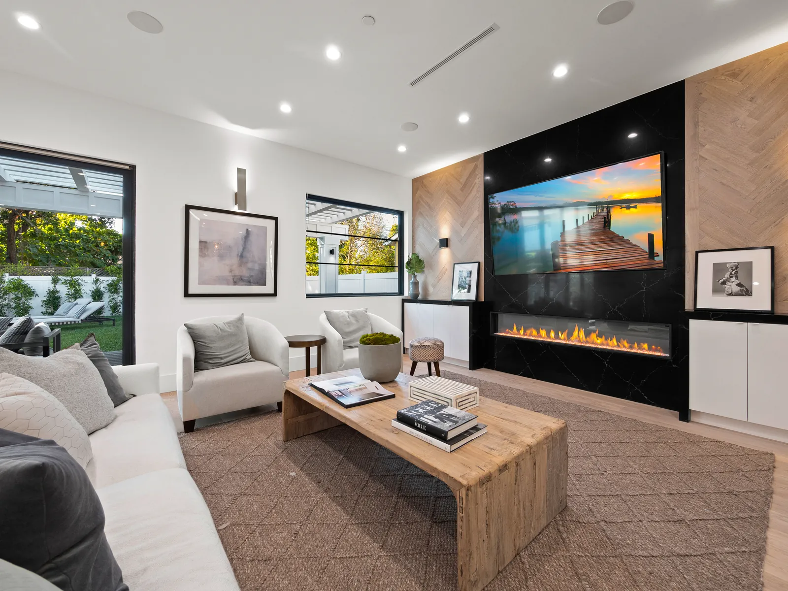 Family room with linear fireplace, herringbone wood accent wall and wide-plank white oak floors
