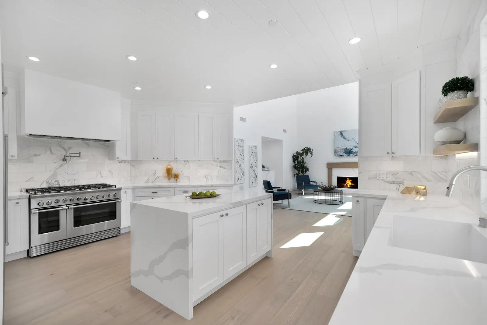 White kitchen with waterfall island and light European white oak hardwood floors