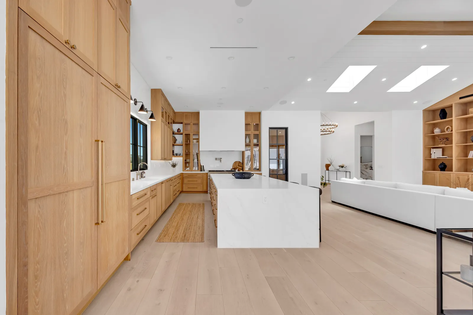 Modern kitchen and great room on light wide-plank oak hardwood flooring