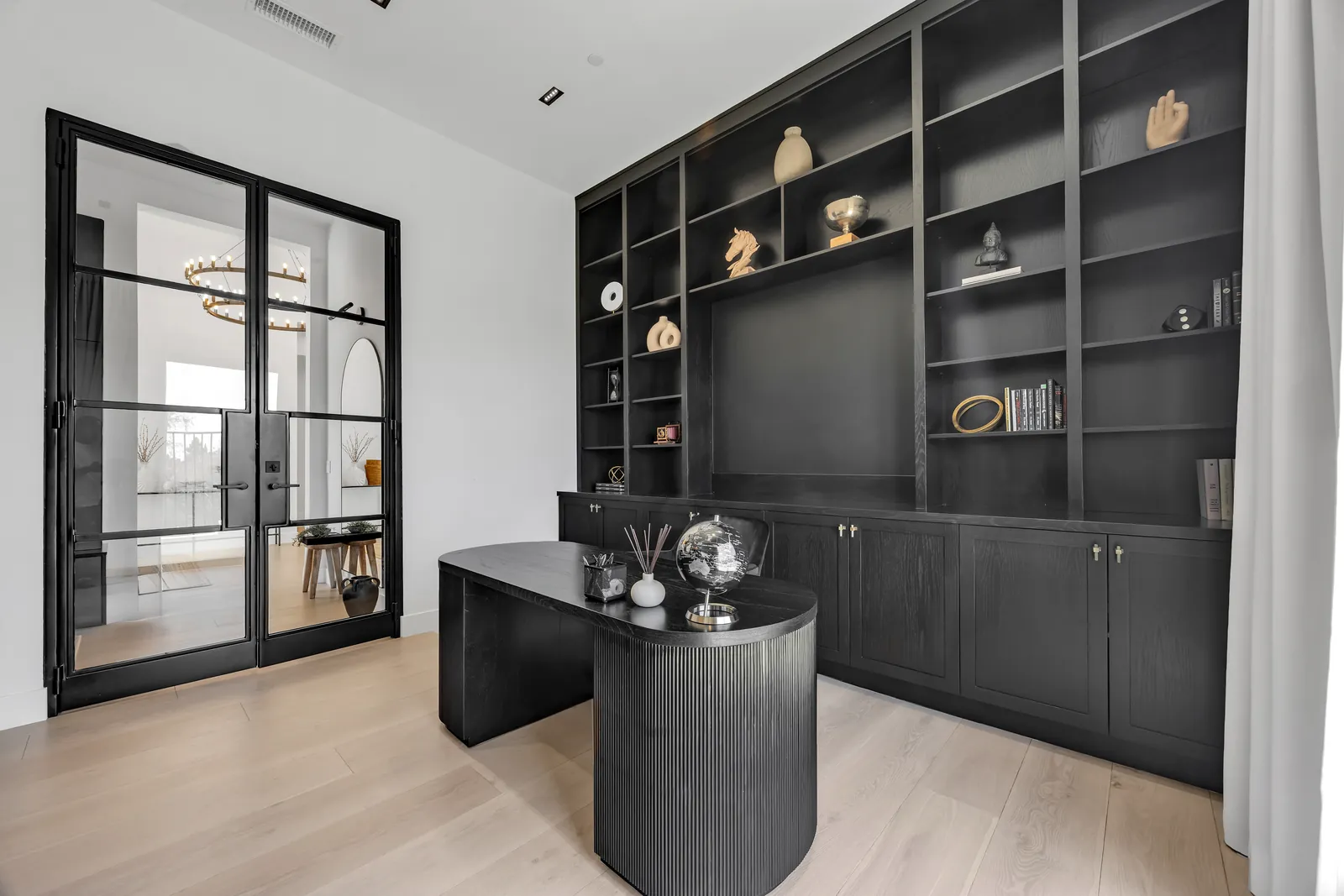 Office with steel-framed glass doors and light oak hardwood floors