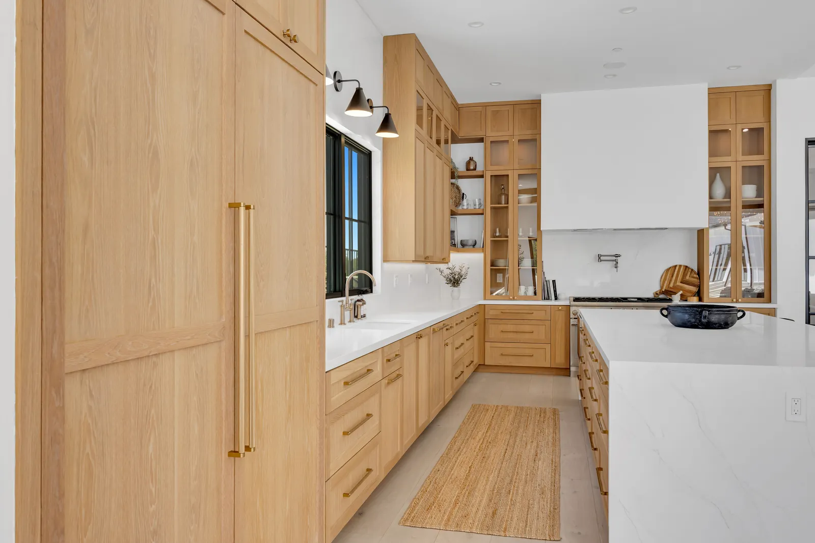 White oak kitchen with brass hardware and wide-plank hardwood floors