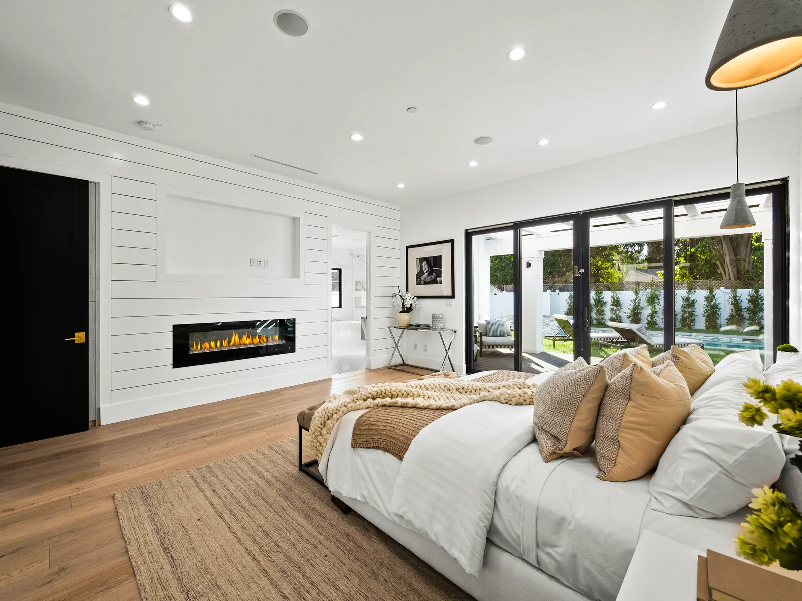 Bedroom with shiplap fireplace wall and 7.5 inch white oak plank flooring