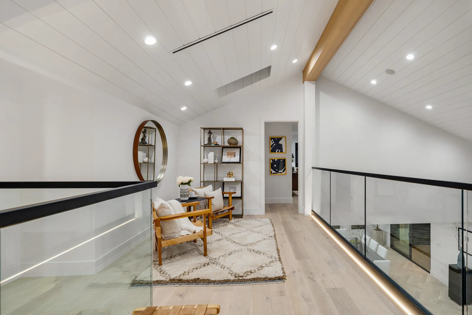 Upstairs loft with wide-plank European oak flooring and glass railings