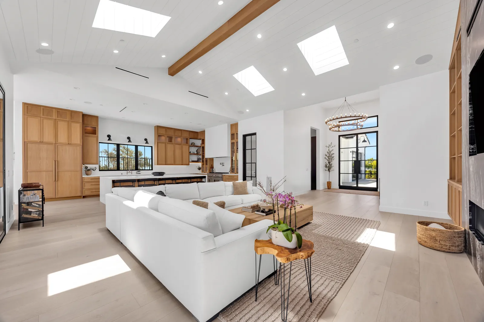 Living room looking toward the front entry on continuous wide-plank oak floors