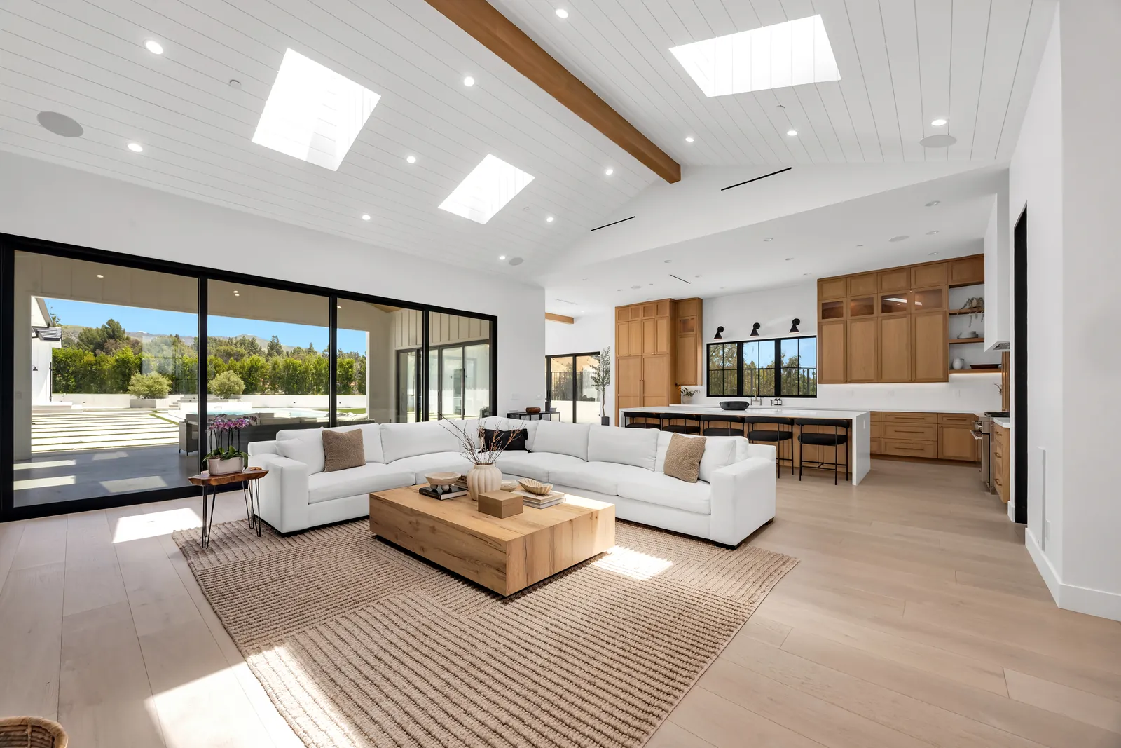 Open great room flowing into the kitchen on wide-plank light oak flooring
